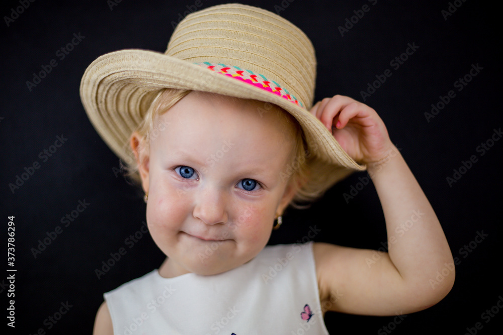 little girl on a black background with an imaginary facial expression, blue eyes and blonde hair little girl on a black background with an imaginary facial expression, blue eyes and blonde hair