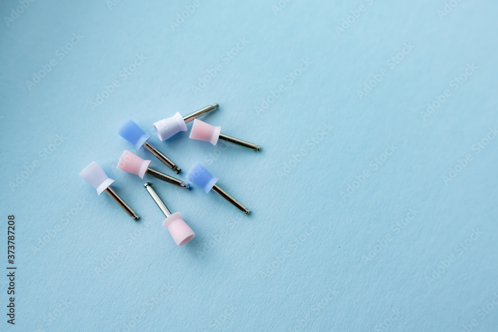 set of dental burs for polishing fillings on a blue background. blue and yellow woods on the background. vertical photo. Tools for the work dentist close up background set of dental burs for polishing fillings on a blue background. blue and yellow woods on the background. vertical photo. Tools for the work dentist close up background