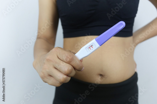 Pregnancy test tool in woman's hand.