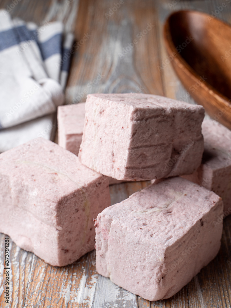 Pink cubes of organic berry marshmallow, catalogue photo on a wooden background