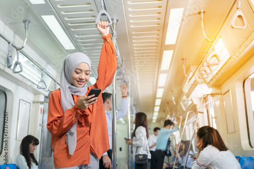 Beautiful Muslim woman playing mobile phone on her way to work