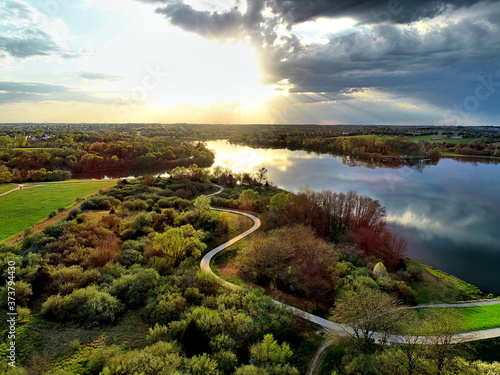 Sunrays break through storm clouds over Standing Bear Lake - Omaha.