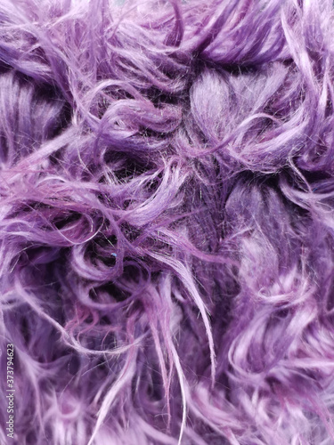 Close up of a purple dyed sheepskin rug as a background