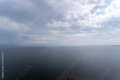 Irkutsk region, Olkhon, Baikal lake, July 2020: summer evening with dramatic sky over smooth water
