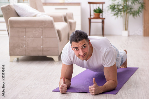 Young male starting day with morning exercises