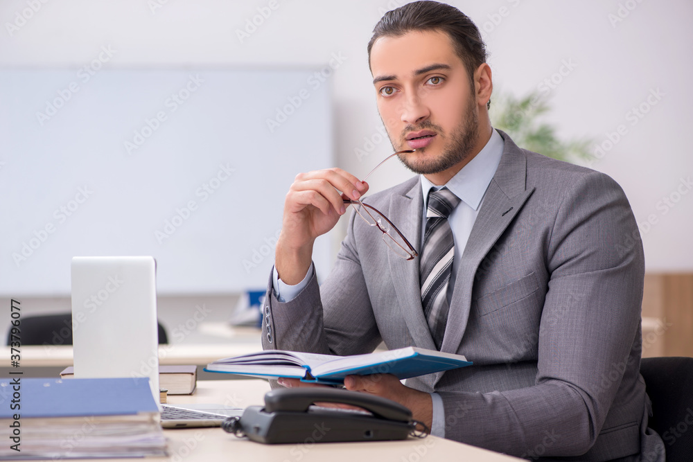 Young male employee working in the office Young male employee working in the office