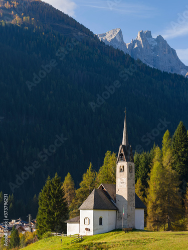 The church, in the background Focobon mountain range in the Pale di San Martino. Caviola, part of Falcade alto in Val Biois, Italy. photo
