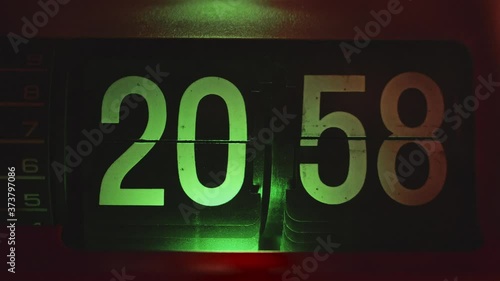 Retro old vintage flip clock with orange body and green or teal light. Getting late, time to sleep. Timelapse with dolly zoom effect.