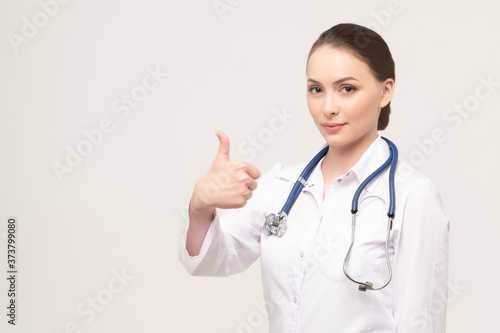 Portrait of an attractive young female doctor showing thumb up gesture
