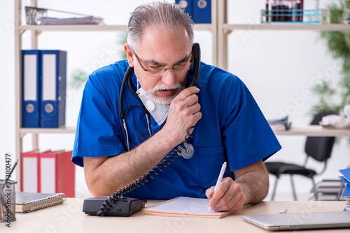 Old male doctor working in the clinic