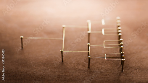 Hierarchy  command chain  company   organization structure or layer and grouping concept image. Top down structure made from gold wires and nails on rustic wooden surface. Shallow depth of field.