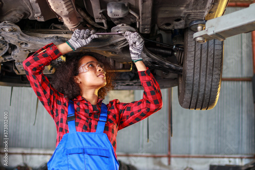 Female auto mechanic working at the repair shop.