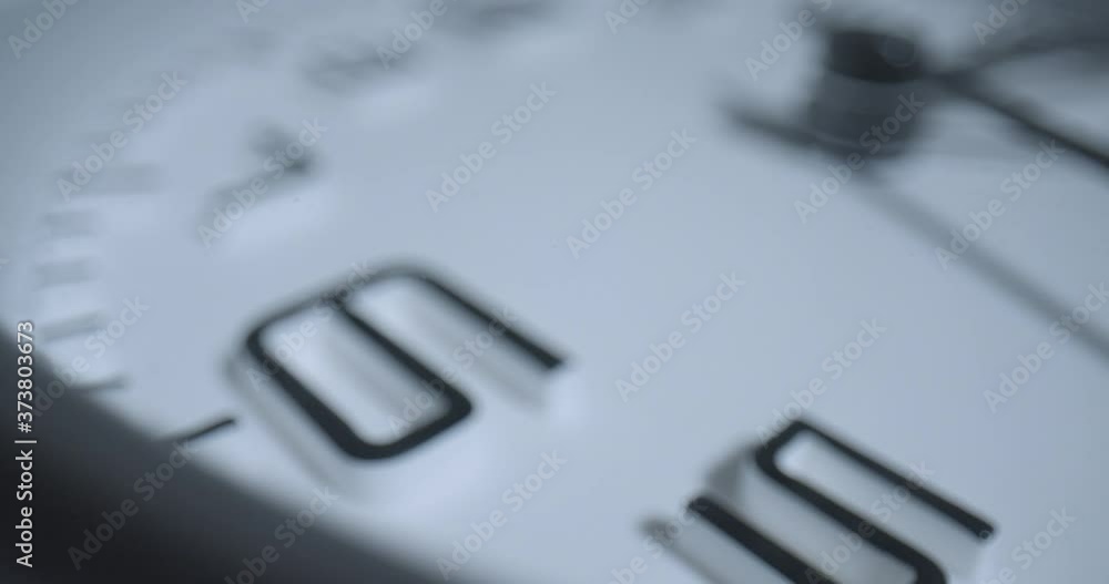 Seconds Pass 6 O'Clock, Rack Focus. Extreme macro wide angle close up as the second hand ticks past the 6 on a small alarm clock with raised 3D numbers.