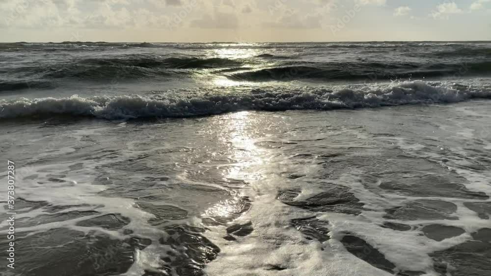 pattern of waves crashing onto the shore at sunrise pattern of waves crashing onto the shore at sunrise