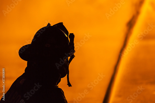 USA, Massachusetts, Cape Ann, Rockport. Fourth of July parade, firemen silhouettes by bonfire.