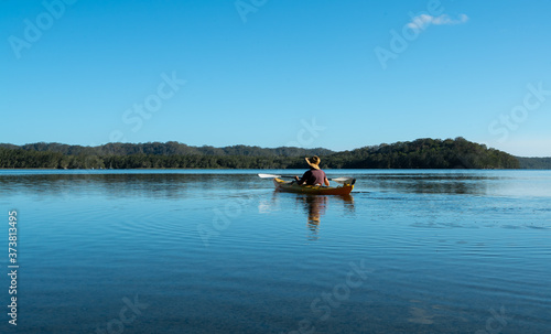 Man kayaking across a lake in Bungwahl, Australia © Paul