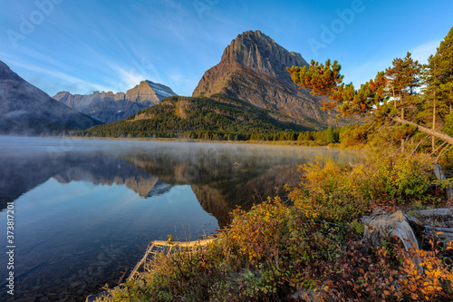 Grinnell Point and Mt. Gould reflection into Swiftcurrent Lake in early autumn in Glacier National Park, Montana, USA photo