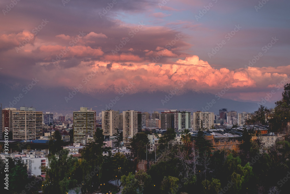 Fototapeta premium Panoramic view of beautiful cloudscape and sunset sky over Santiago skyline and The Andes Mountains, Chile
