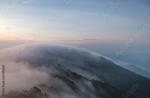 Morning mist covered mountains and trees Low light and noise