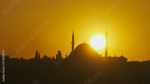 close up of a mosque in istanbul with the sun setting behind it