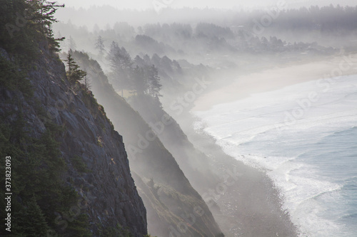 USA, Oregon, Oswald West State Park and cliff bluffs looking towards Manzanita with lifting fog photo