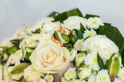  Wedding rings on the background of a bouquet of roses close-up.