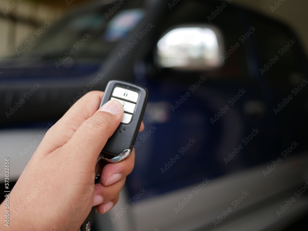 closeup of hand pressing on the remote control system of modern car. closeup of hand pressing on the remote control system of modern car.