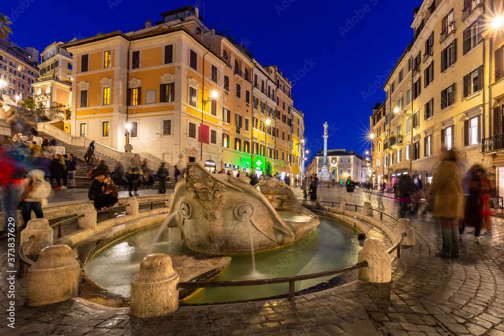 Fountain on the Piazza di Spagna square and the Spanish Steps in Rome at dusk, Italy