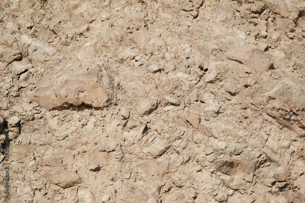 Rocky hill. Light beige abstract textured background. Surface. Terrain gravel wall. Cracked rock stones. Copy space