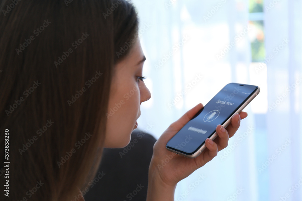 Woman using voice search on smartphone indoors, closeup