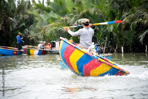 HOI AN, VIETNAM-December 9,2019 : Fisherman demonstrates spinning on round basket boat . is a unique Vietnamese at Cam thanh village.