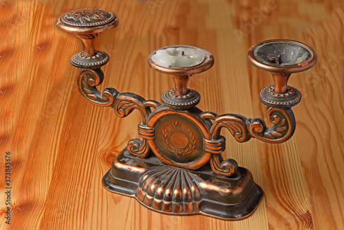 Antique candle holder on a wooden surface close up photo