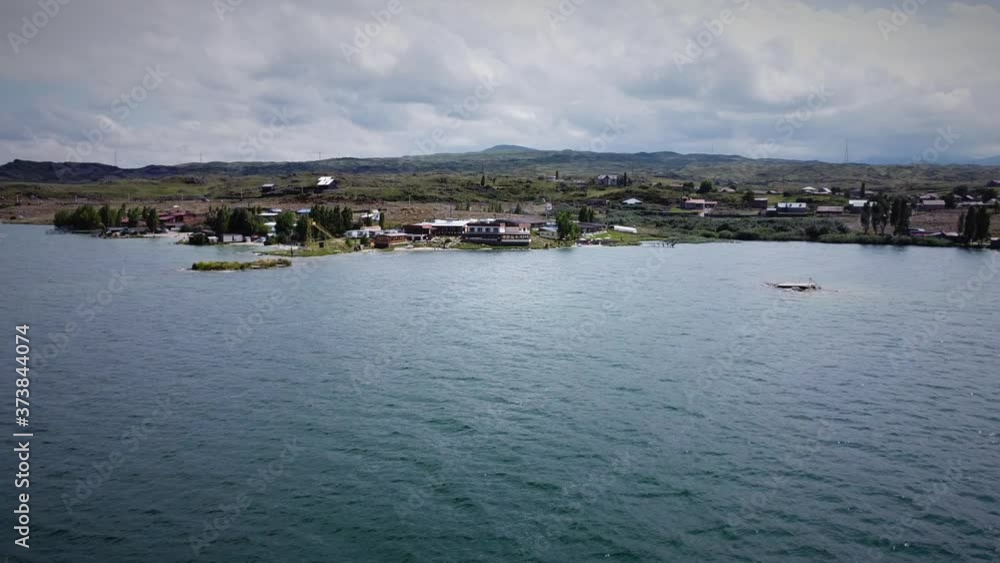 Drone Flying forward (zooming in) to the Coastline with the Hotel Building and beautiful mountains at the background Drone Flying forward (zooming in) to the Coastline with the Hotel Building and beautiful mountains at the background