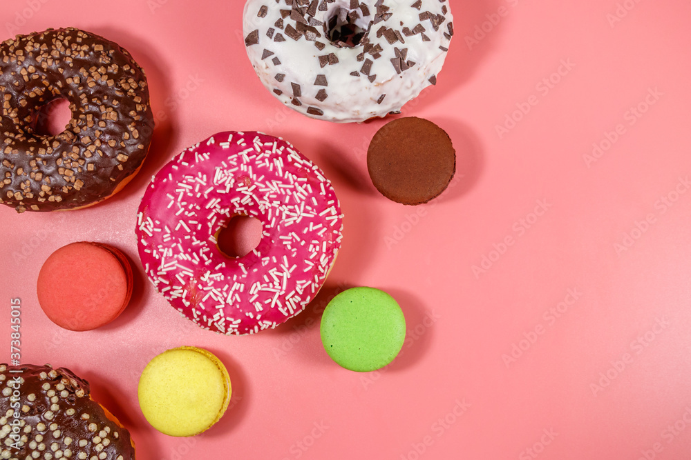 Tasty donuts and macaroons on pink background. Top view Tasty donuts and macaroons on pink background. Top view
