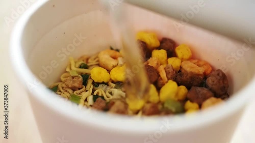 カップラーメンにお湯を注ぐ