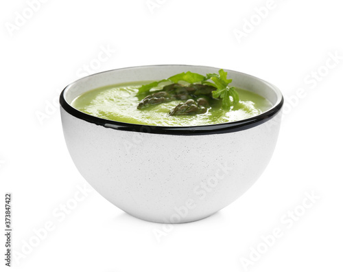 Delicious asparagus soup with arugula isolated on white