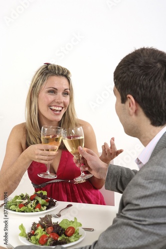 Man and woman chatting and drinking while having dinner together