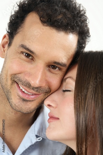 Man with his face close to woman while looking at camera
