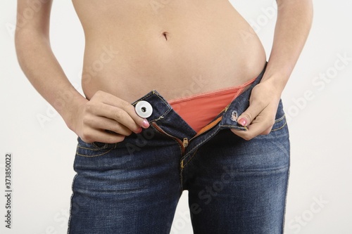 Woman unzipping her jeans