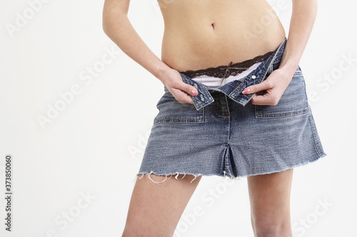 Woman unzipping her denim skirt