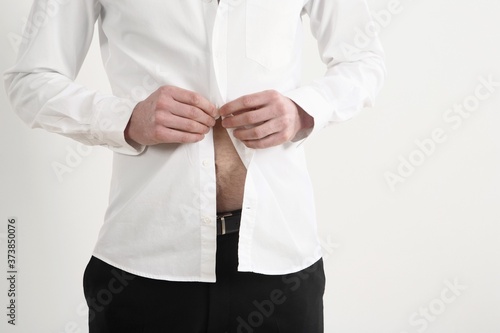 Businessman buttoning his shirt
