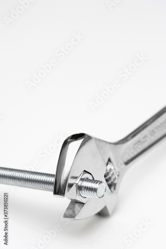 Crescent wrench tightening nut into bolt