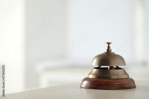 Hotel service bell on table indoors. Space for text