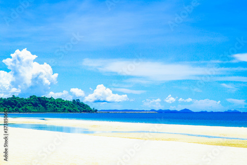 Beautiful beach with white sand,Blue ocean water and blue sky with white clouds in sunny day. Soft focus.