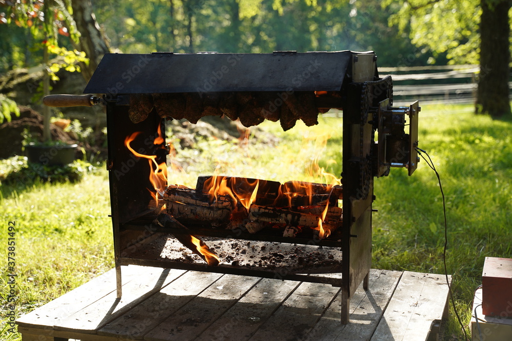 2 trussed chickens roasting over an open log fire 2 trussed chickens roasting over an open log fire