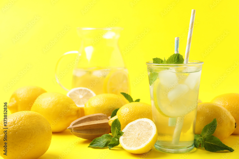 Natural freshly made lemonade with squeezer on yellow background. Summer refreshing drink Natural freshly made lemonade with squeezer on yellow background. Summer refreshing drink