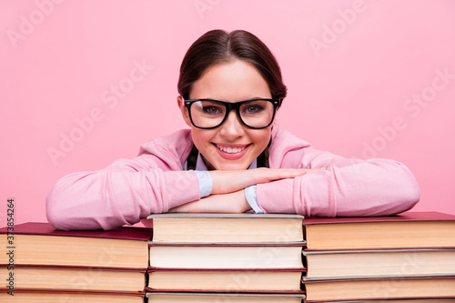 Closeup photo of pretty student lady two braids leaning hands head books pile library worker fond of reading love her job work wear shirt pullover specs isolated pastel pink color background