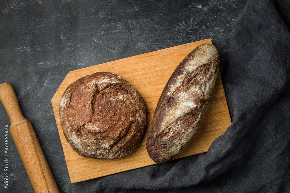 Rustic bread on dark background. Flat lay.