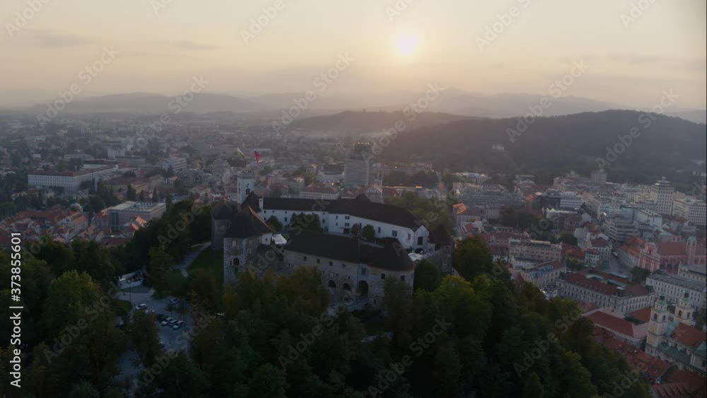 Cinematic drone view of Ljubljana castle, sun and Ljubljana city Cinematic drone view of Ljubljana castle, sun and Ljubljana city