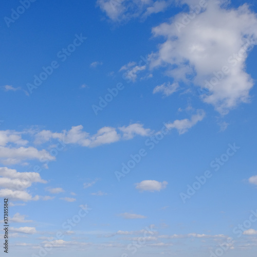 Blue spring sky with white clouds. Beautiful background.